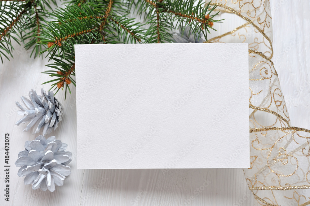 Mockup Christmas greeting card with tree and gold gift ribbon, flatlay on a white wooden background, with place for your text Mockup Christmas greeting card with tree and gold gift ribbon, flatlay on a white wooden background, with place for your text