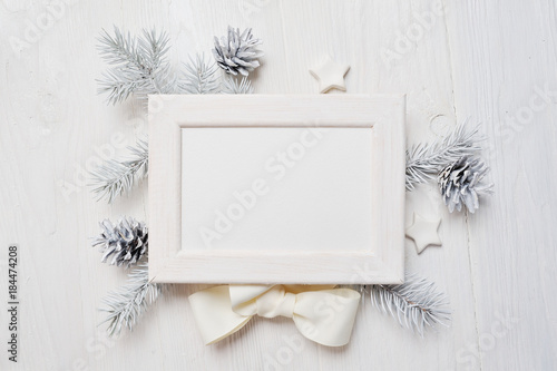 Mockup Christmas greeting card top view and white frame, flatlay on a white wooden background with a ribbon, with place for your text