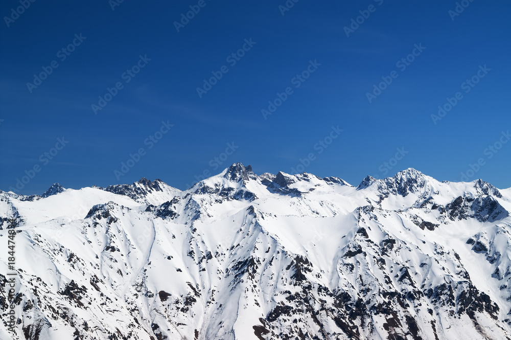 Snow covered mountains and blue sky at sun cold day