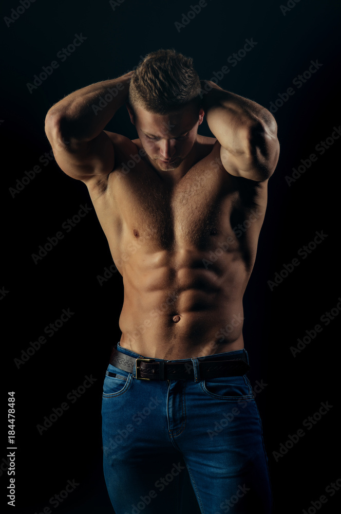 Man sportsman show muscular torso in jeans on black background Man sportsman show muscular torso in jeans on black background