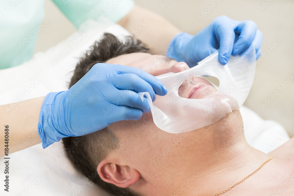 Man in the mask cosmetic procedure in spa salon Man in the mask cosmetic procedure in spa salon
