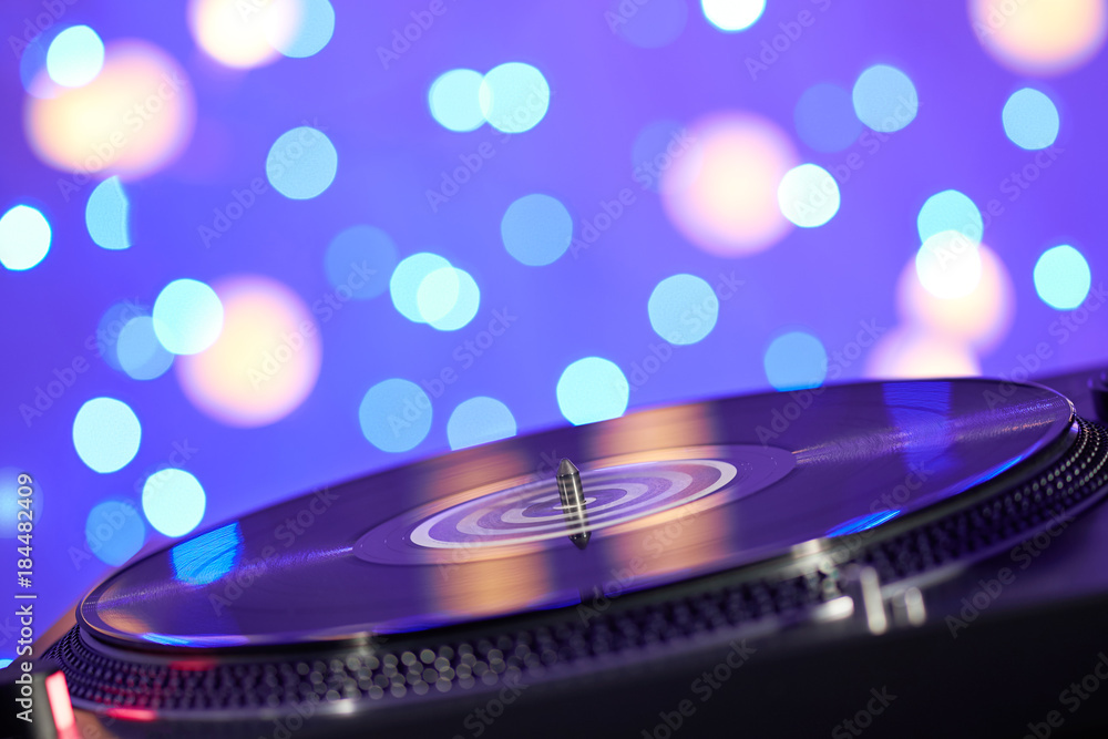 Blurred turntable vinyl record player. Sound technology for DJ to mix &  play music. Vintage vinyl record player on a background decorations for a  party, bright disco lights Stock Photo | Adobe