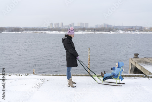 Fotografía wooman with a child on a sled near a river