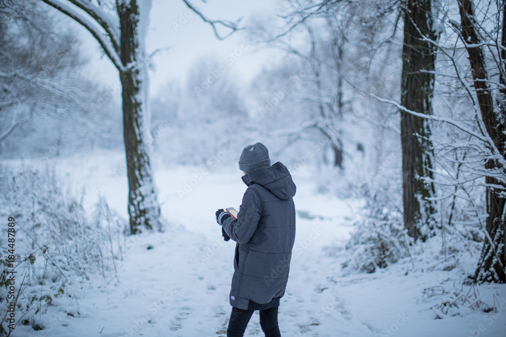 Girl taking photos in the snow forest 