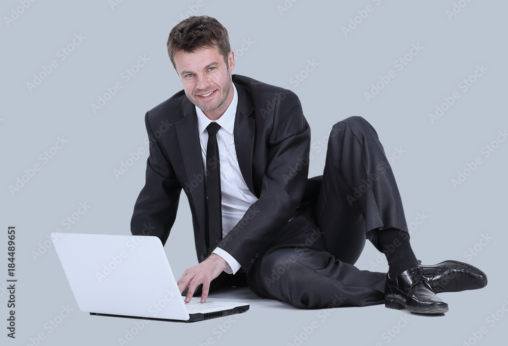 Handsome young business man workin on laptop. Isolated on gray. Handsome young business man workin on laptop. Isolated on gray.