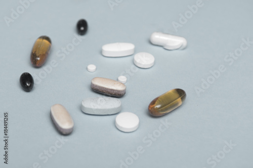 Prescription drugs isolated on a blue background, assorted tablets