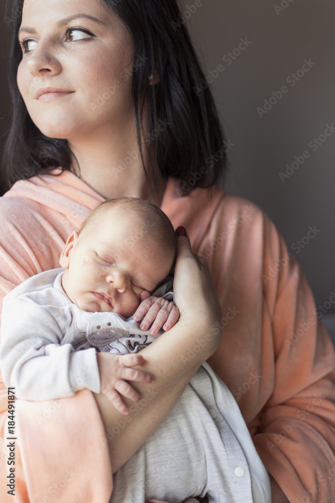 pretty woman holding a newborn baby in her arms pretty woman holding a newborn baby in her arms
