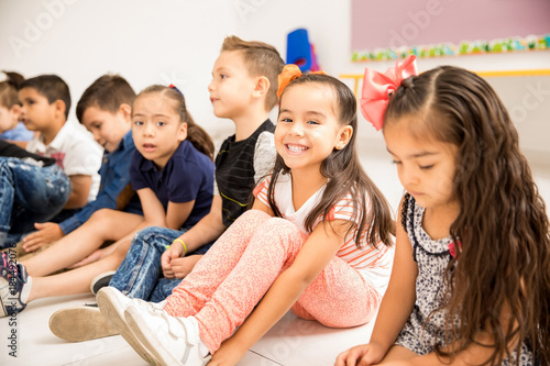 Preschool kids sitting on the classroom floor