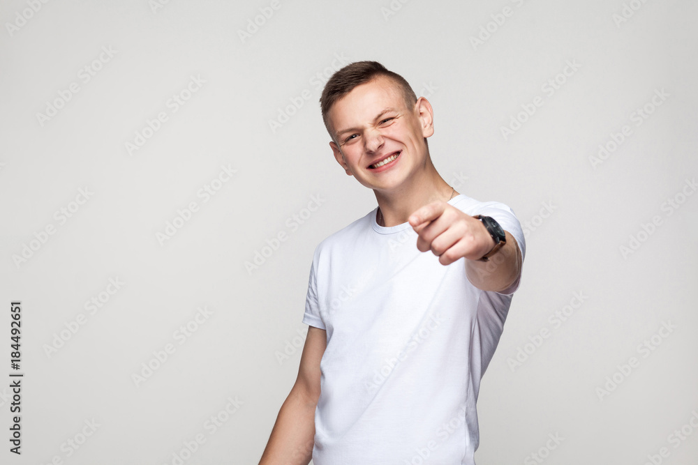 Happiness young boy pointing finger at camera and toothy smiling Happiness young boy pointing finger at camera and toothy smiling