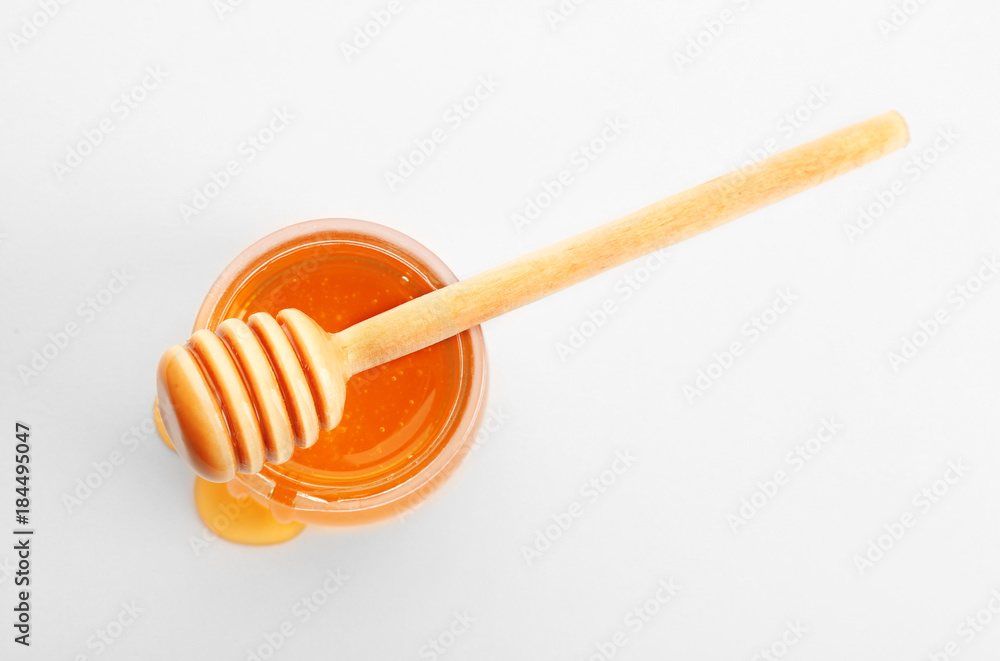 Jar of honey with dipper, isolated on white Jar of honey with dipper, isolated on white
