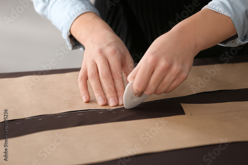 Young tailor working with sewing pattern, closeup