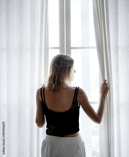 Rear view of Caucasian woman standing by the window