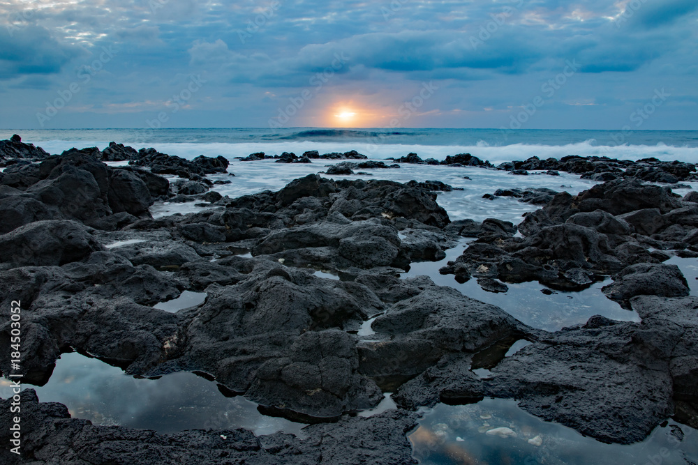 Sunrise on a cloudy day with foreground of rocks, Sandy beach, Oahu, Hawaii Sunrise on a cloudy day with foreground of rocks, Sandy beach, Oahu, Hawaii