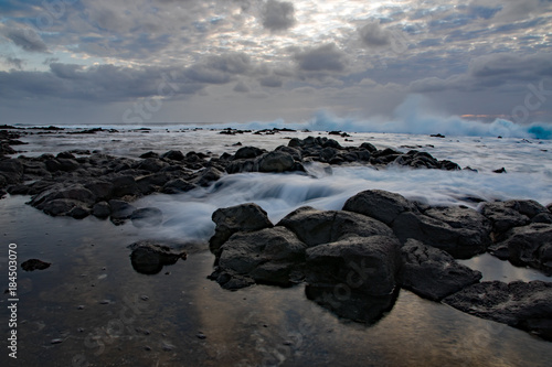 Long exposure of waves falling over weathered rocks at Sandy beach, Oahu, Hawaii