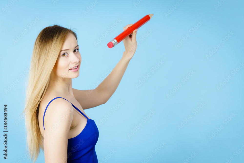 Blonde woman holds big pencil in hand drawing Blonde woman holds big pencil in hand drawing