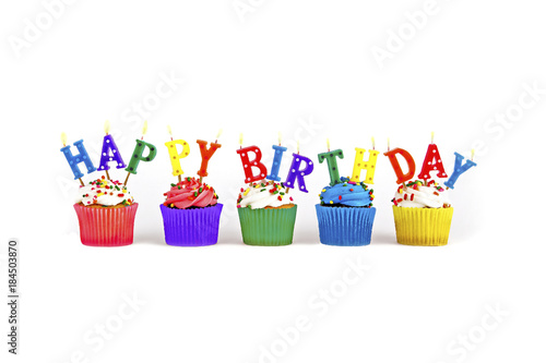 Colorful happy birthday candles on cupcakes