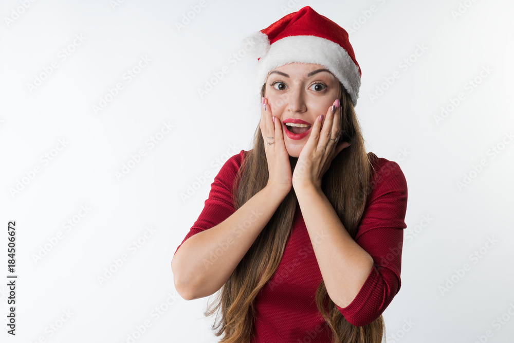 portrait of young christmas woman wearing red santa claus hat isolated on white background, copy space. She has shock, surprise emotion on her face portrait of young christmas woman wearing red santa claus hat isolated on white background, copy space. She has shock, surprise emotion on her face