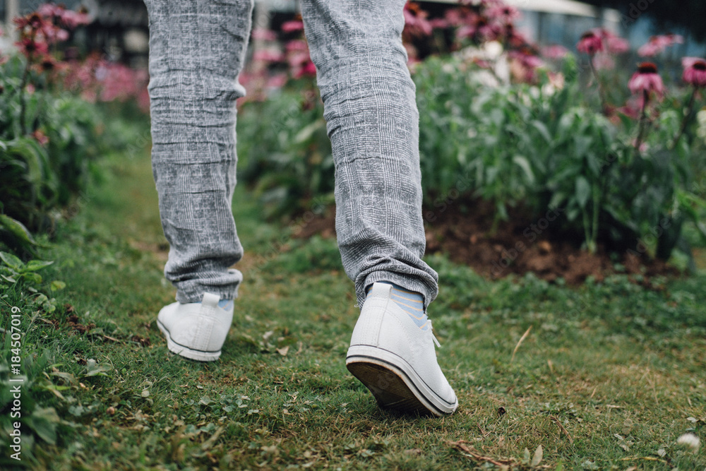 woman walk in garden. girl relax in flowerbed in park