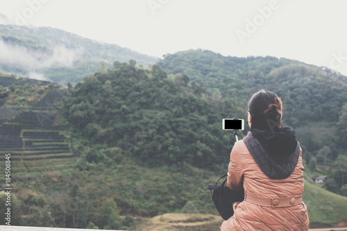 tourist use smart phone to take selfie picture with mountain view. people, travel, nature concept.