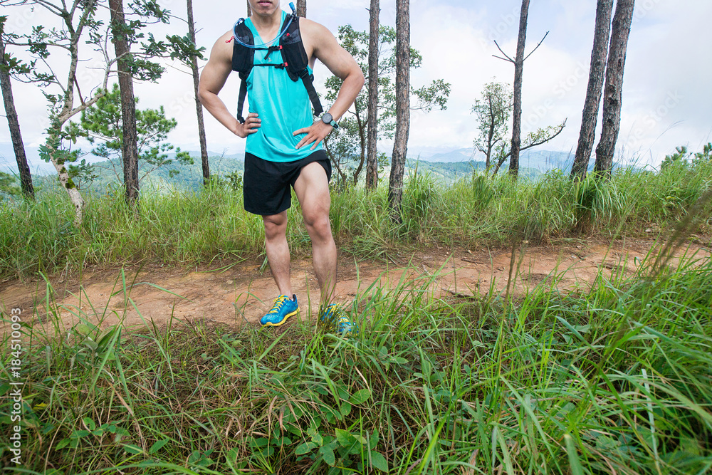 Marathon runner running on rocks in the mountain, Close up of legs compression the socks and the shoes Marathon runner running on rocks in the mountain, Close up of legs compression the socks and the shoes