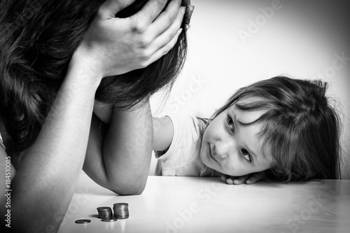 Small family. Single mother has financial problems. Her little daughter calms down sad mother.