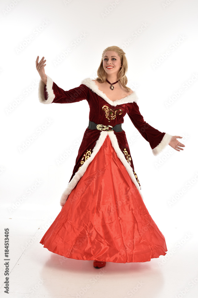 full length portrait of pretty blonde lady wearing red and white christmas inspired costume gown, standing pose on white background. full length portrait of pretty blonde lady wearing red and white christmas inspired costume gown, standing pose on white background.