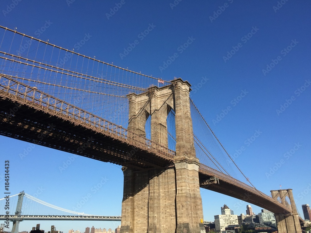 Fototapeta premium Brooklyn bridge and Manhattan bridge over river and buildings in Brooklyn, New York