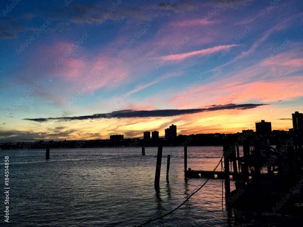 Silhouette city and dock on Hudson River with sunset sky