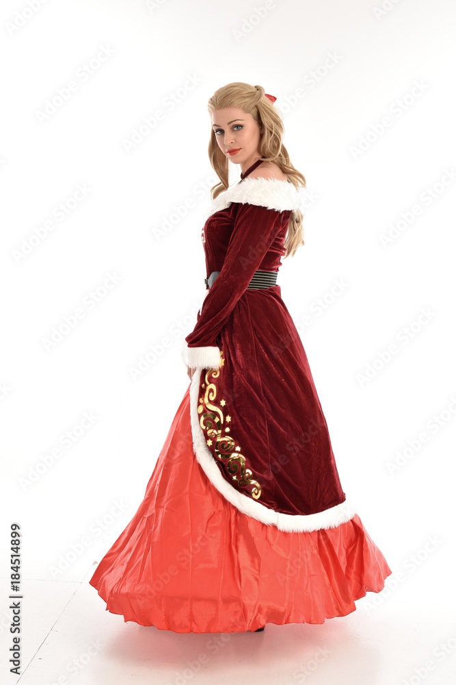 full length portrait of pretty blonde lady wearing red and white christmas inspired costume gown, standing pose on white background. full length portrait of pretty blonde lady wearing red and white christmas inspired costume gown, standing pose on white background.