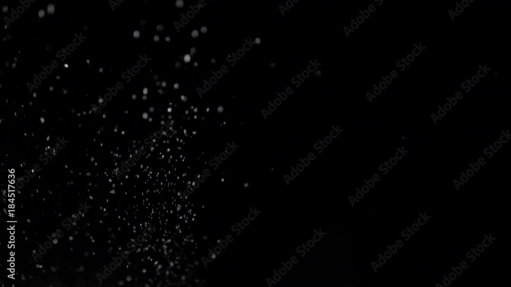 Several snow particles falling down over a black background that you ...