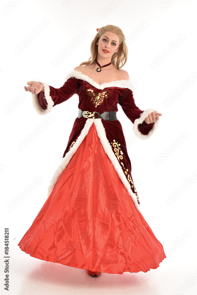 full length portrait of pretty blonde lady wearing red and white christmas inspired costume gown, standing pose on white background. full length portrait of pretty blonde lady wearing red and white christmas inspired costume gown, standing pose on white background.