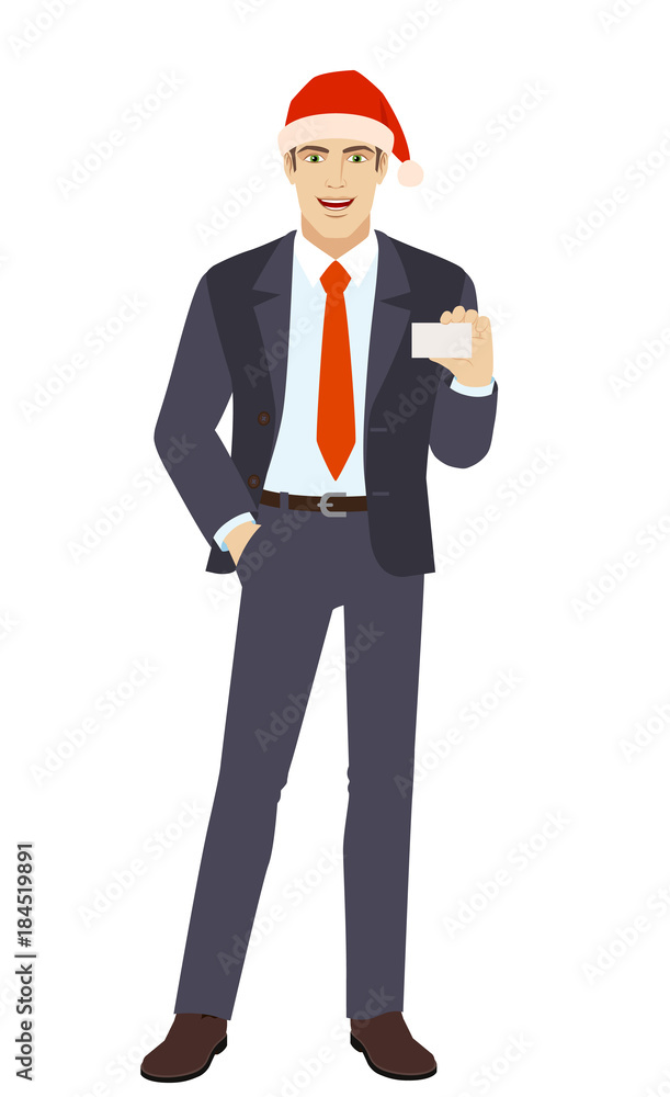 Businessman in Santa hat with hand in pocket showing the business card Businessman in Santa hat with hand in pocket showing the business card