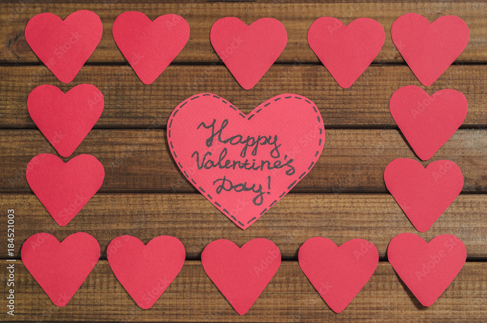 Cut out of red paper hearts on wooden background, congratulation with Valentine's day, top view