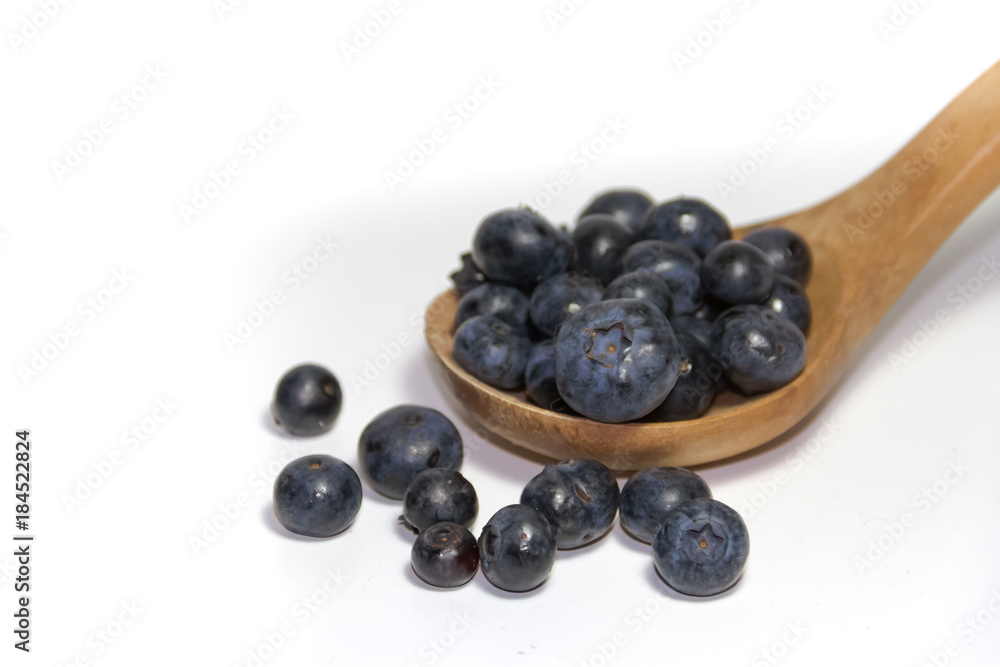 red fruits on white background and wooden spoon red fruits on white background and wooden spoon