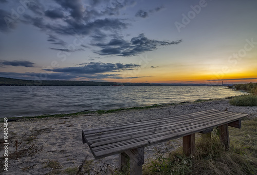 Lonely bench by the sea at sunset