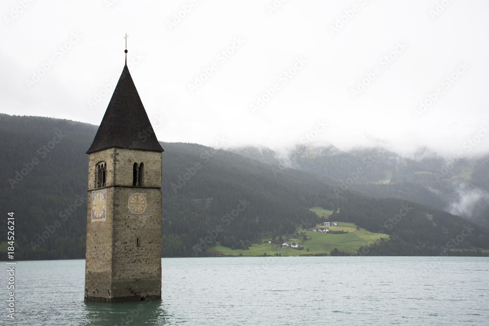 Submerged tower of reschensee church deep in Resias Lake in Bolzano or bozen city at Italy