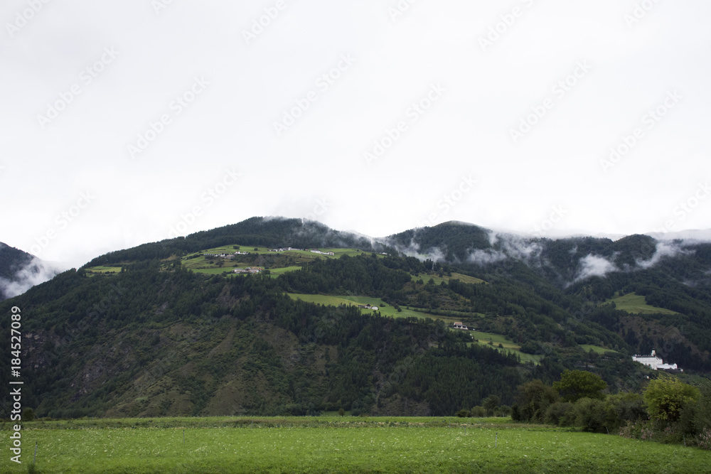 View landscape of mountain and grass field beside road in Schnals city in Bolzano, Austria