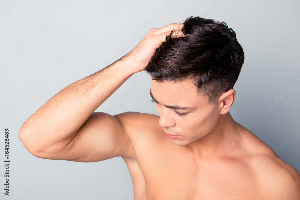 Close up top view photo of clean clear smooth, health fresh hair, confident handsome man is fixing his furfur, isolated on grey background Close up top view photo of clean clear smooth, health fresh hair, confident handsome man is fixing his furfur, isolated on grey background