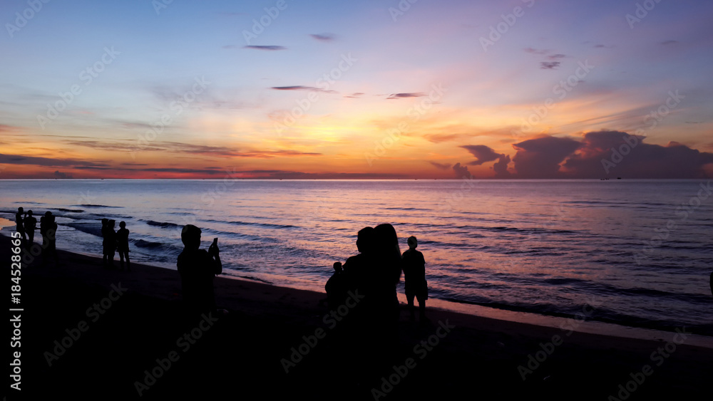 Silhouette of people taking picture of landscape during sunrise Scenic View Of Beach Against Sky During Sunset.
