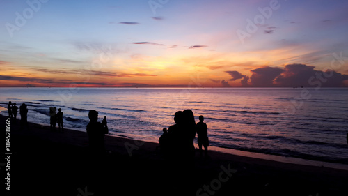 Silhouette of people taking picture of landscape during sunrise Scenic View Of Beach Against Sky During Sunset.