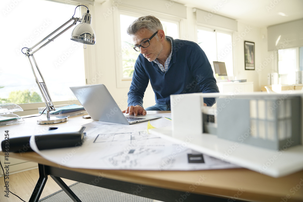 Architect in office working on construction project Architect in office working on construction project