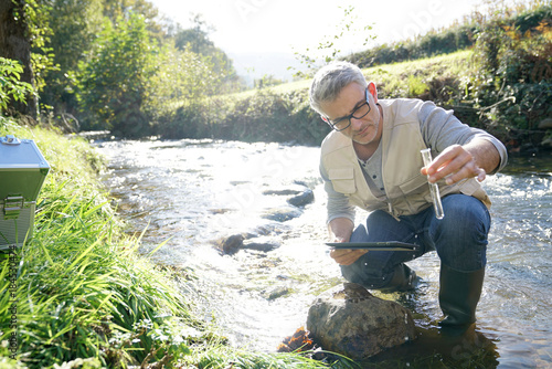 Biologist testing water quality of river photo