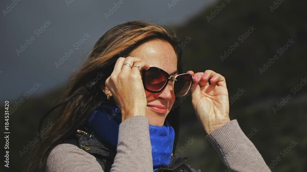 Close up woman face portrait. Woman wearing glasses, looking straight at the camera, smiling. Sun rays. Close up Close up woman face portrait. Woman wearing glasses, looking straight at the camera, smiling. Sun rays. Close up