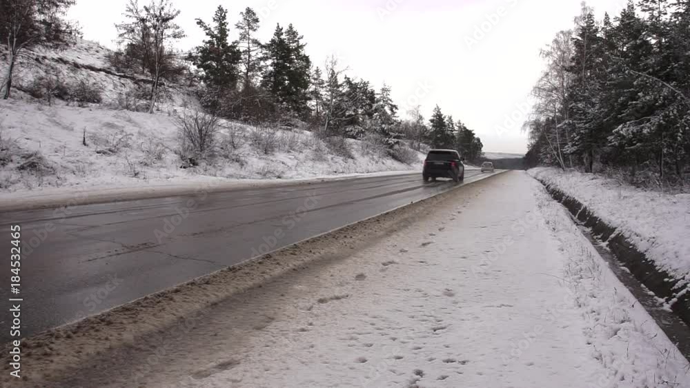 The highway during the winter. The cars circulate speedily on the snowy highway The highway during the winter. The cars circulate speedily on the snowy highway
