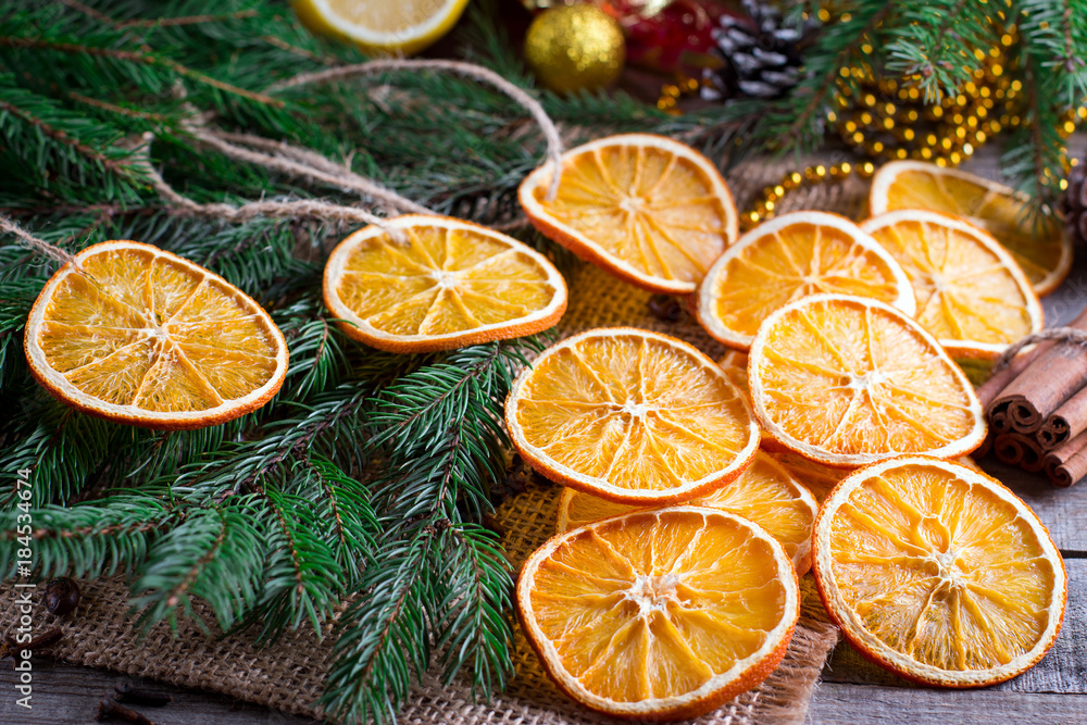 Christmas tree from dry oranges, cinnamon and anise stars on wooden rustic table and fir tree in background Christmas tree from dry oranges, cinnamon and anise stars on wooden rustic table and fir tree in background