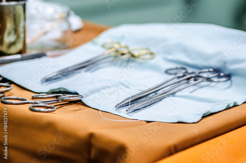 Prepared sterile needles with medical threads for sewing wounds on the operating table near the operating table.