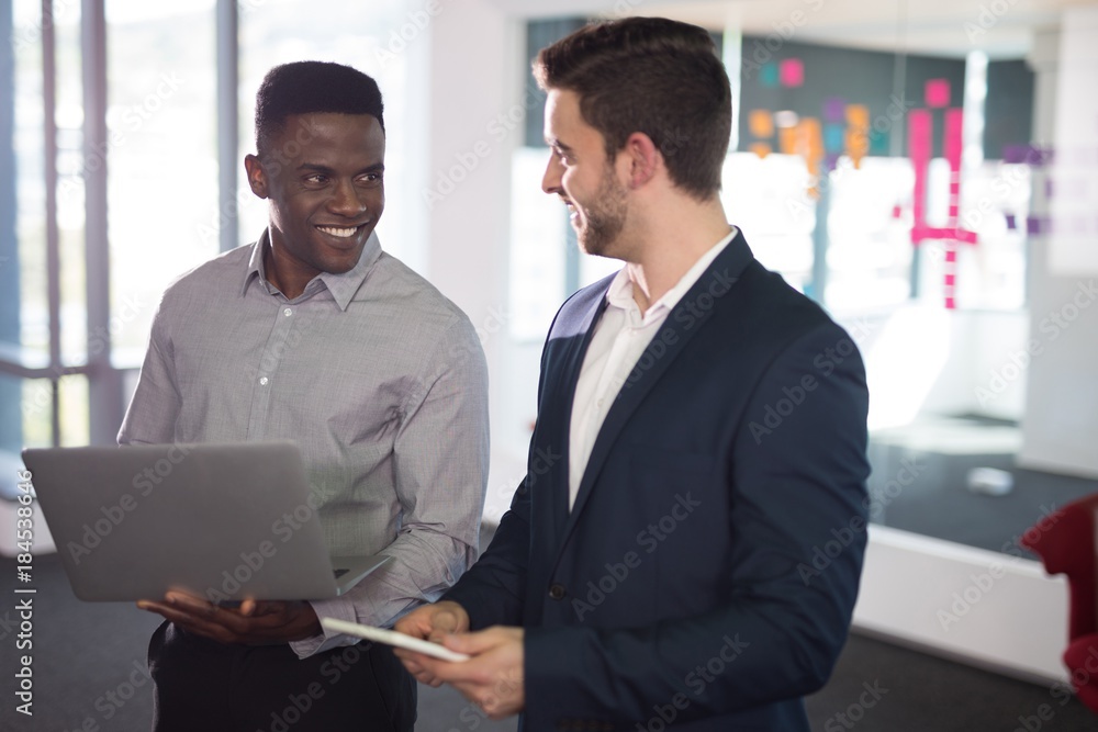 Happy male executives using laptop and digital tablet Happy male executives using laptop and digital tablet