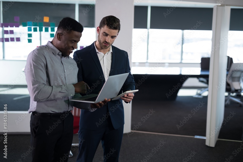 Happy male executives using laptop and digital tablet Happy male executives using laptop and digital tablet