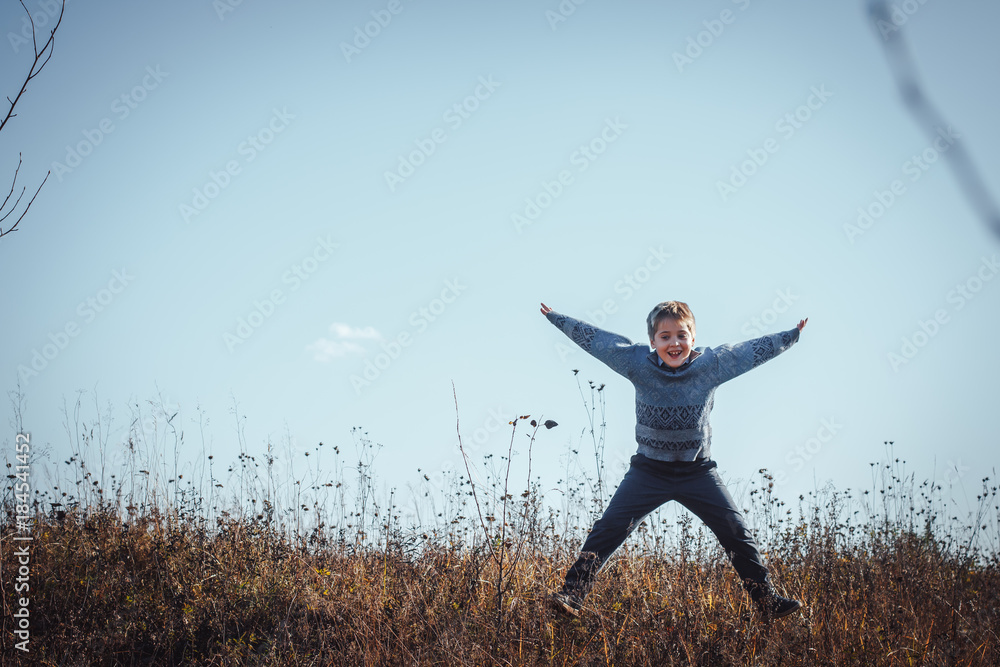 Funny blond boy in yellow grass in an autumn day Funny blond boy in yellow grass in an autumn day