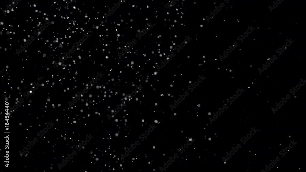 Several snow particles falling down over a black background that you ...